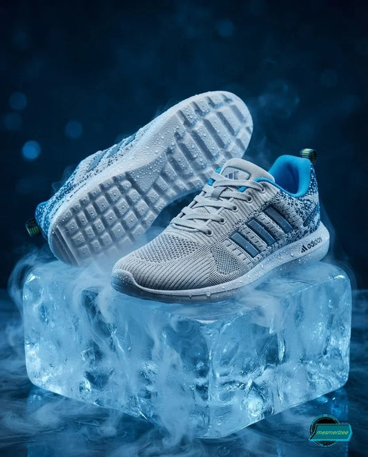 Adidas light grey mesh running sneakers on a block of ice with mist.